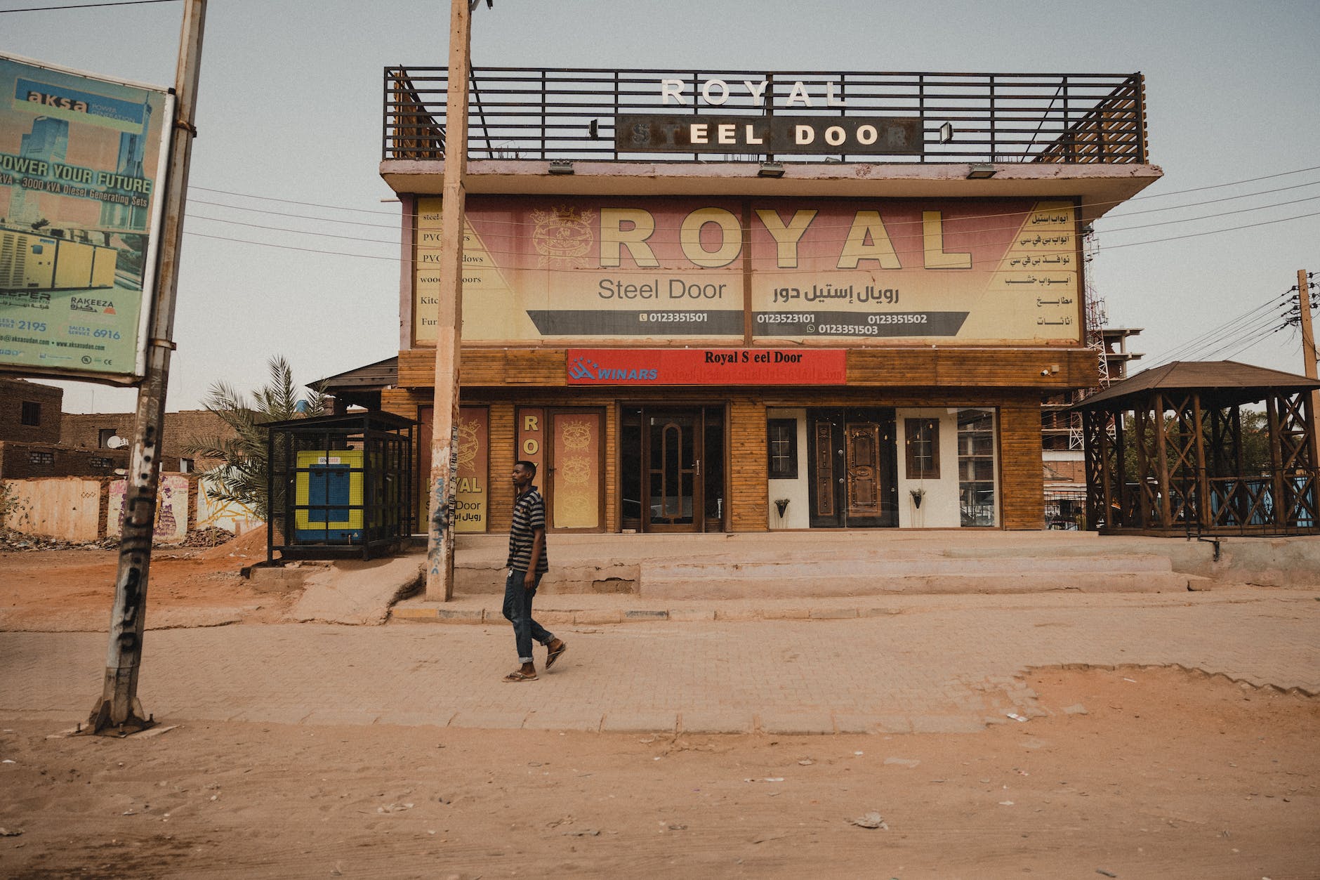 man on empty street passing by abandoned store
